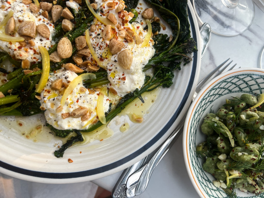 a plate of broccolini and a small pasta dish